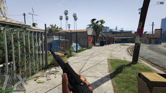 Best GTA 5 mods - the first person view of a man holding a gun in the middle of a street.